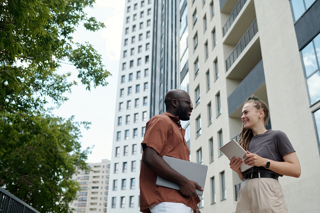 Happy young intercultural white collar workers having discussion outdoor