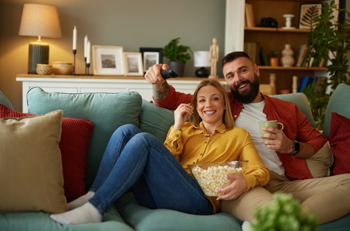 Privatpersoner NokeyFy Två personer som sitter i en soffa och äter popcorn